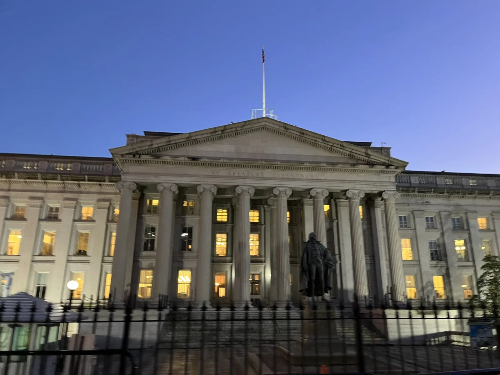 Front facade of the U.S. Treasury Department building in Washington, lit at dusk