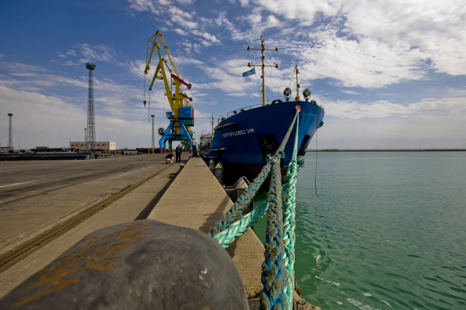 A blue cargo ship moored beside cranes at the Caspian port of Aktau, Kazakhstan