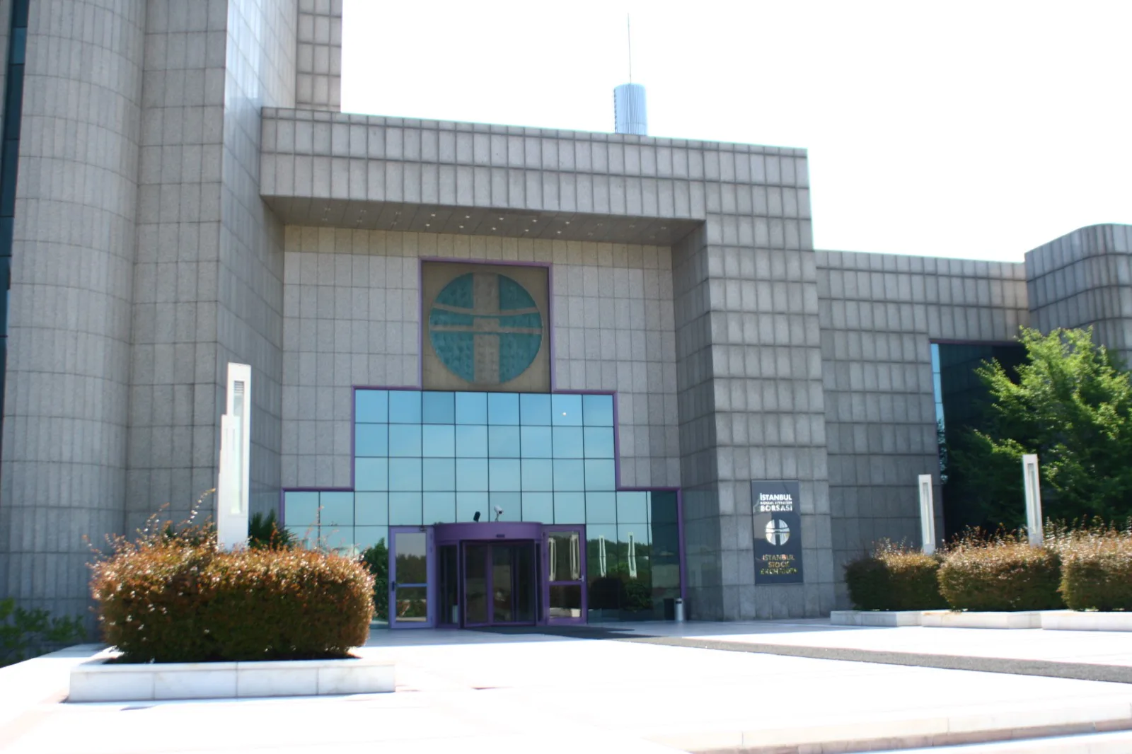 Вход и вывеска с логотипом облицованного гранитом здания Borsa Istanbul (бывшая Стамбульская фондовая биржа) в Истинье