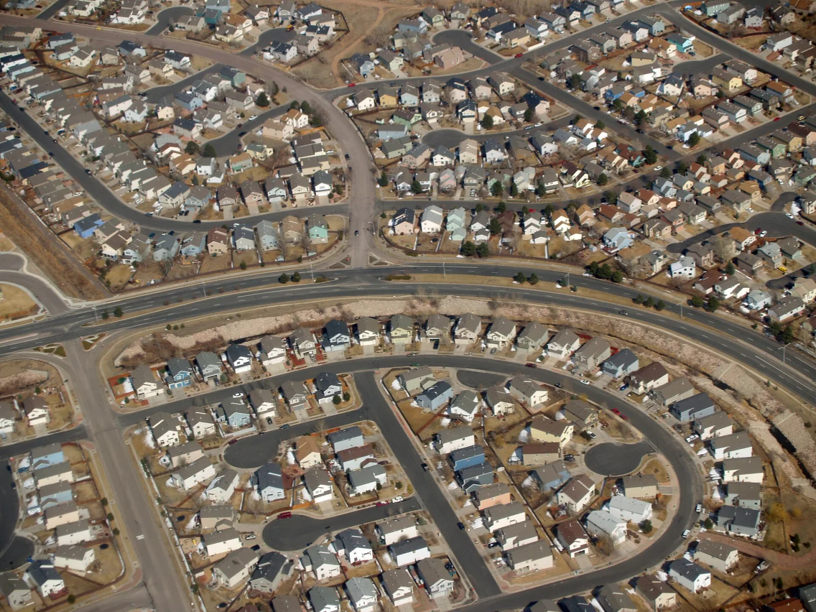 Aerial view of a suburban neighbourhood of detached houses lined up along curving streets