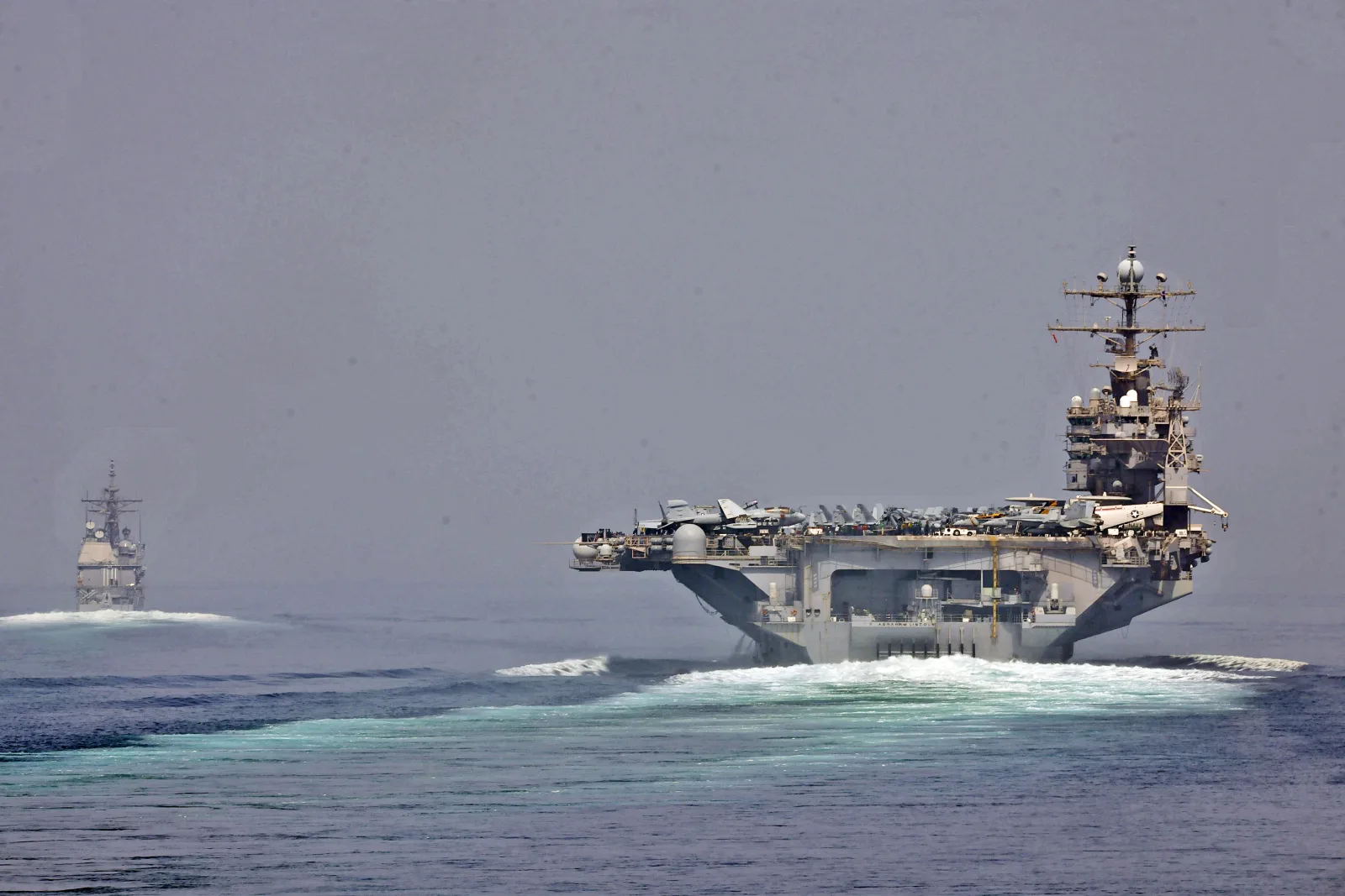 A US guided-missile cruiser and an aircraft carrier transiting the Strait of Hormuz