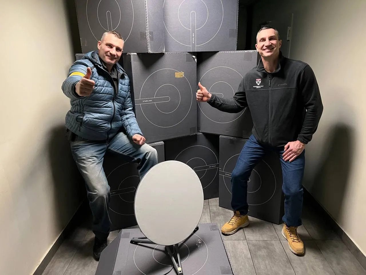 Vitali and Wladimir Klitschko in Kyiv beside boxed Starlink satellite internet terminals and a receiver dish