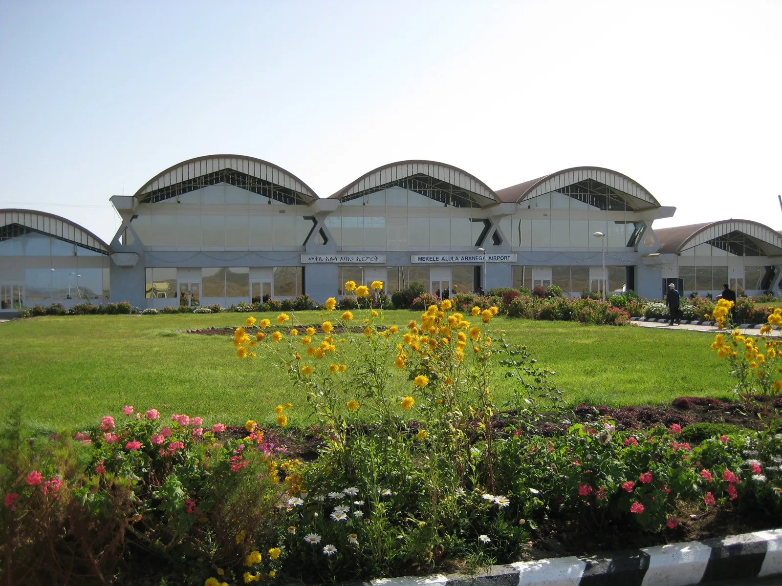 The arched roof of the Mekelle Alula Aba Nega Airport terminal building and the flower garden in front of it